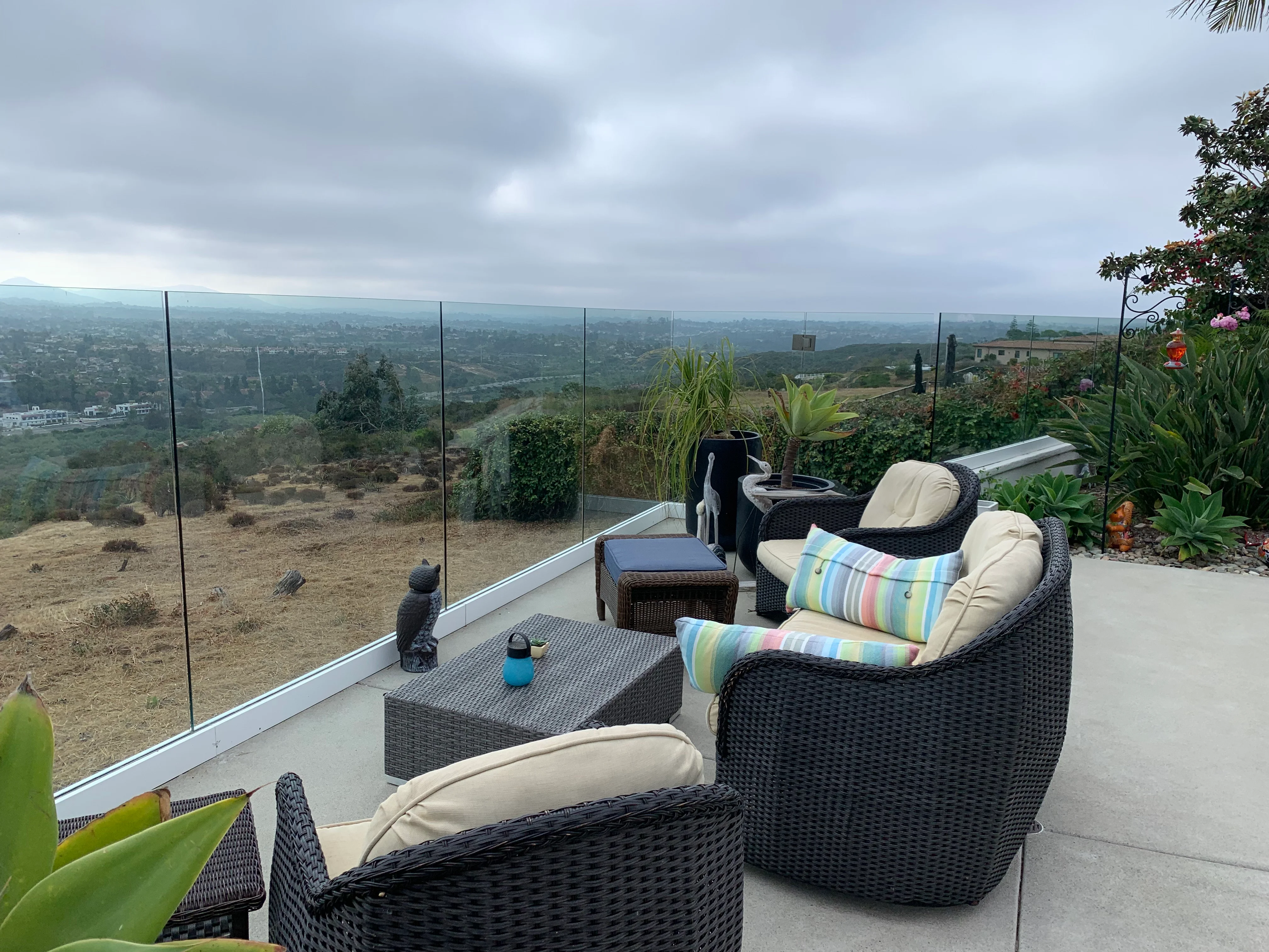 Cleaned frameless glass panels on hillside patio overlooking San Diego valley landscape