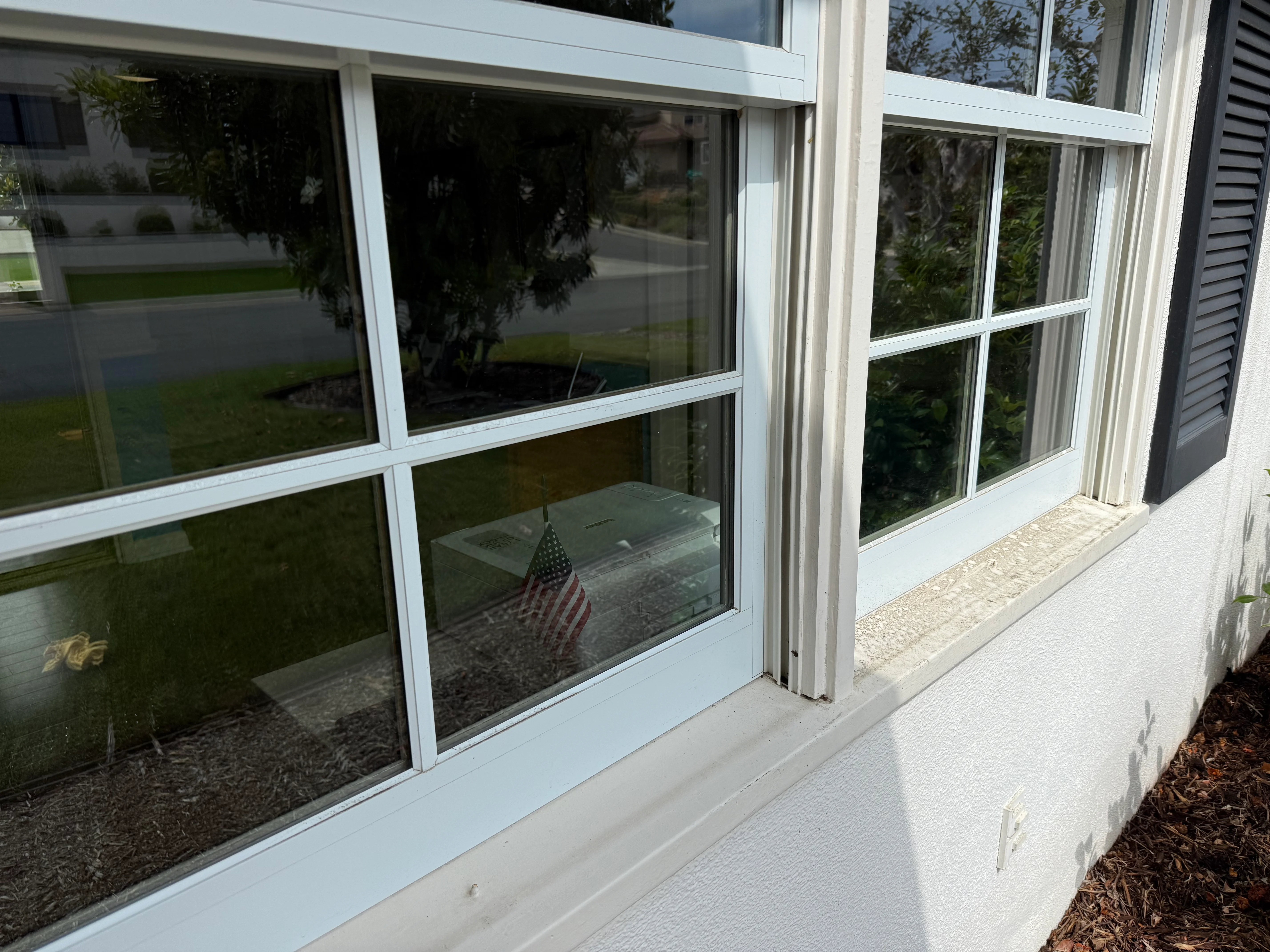 Clean white-framed residential windows with grid pattern on home exterior