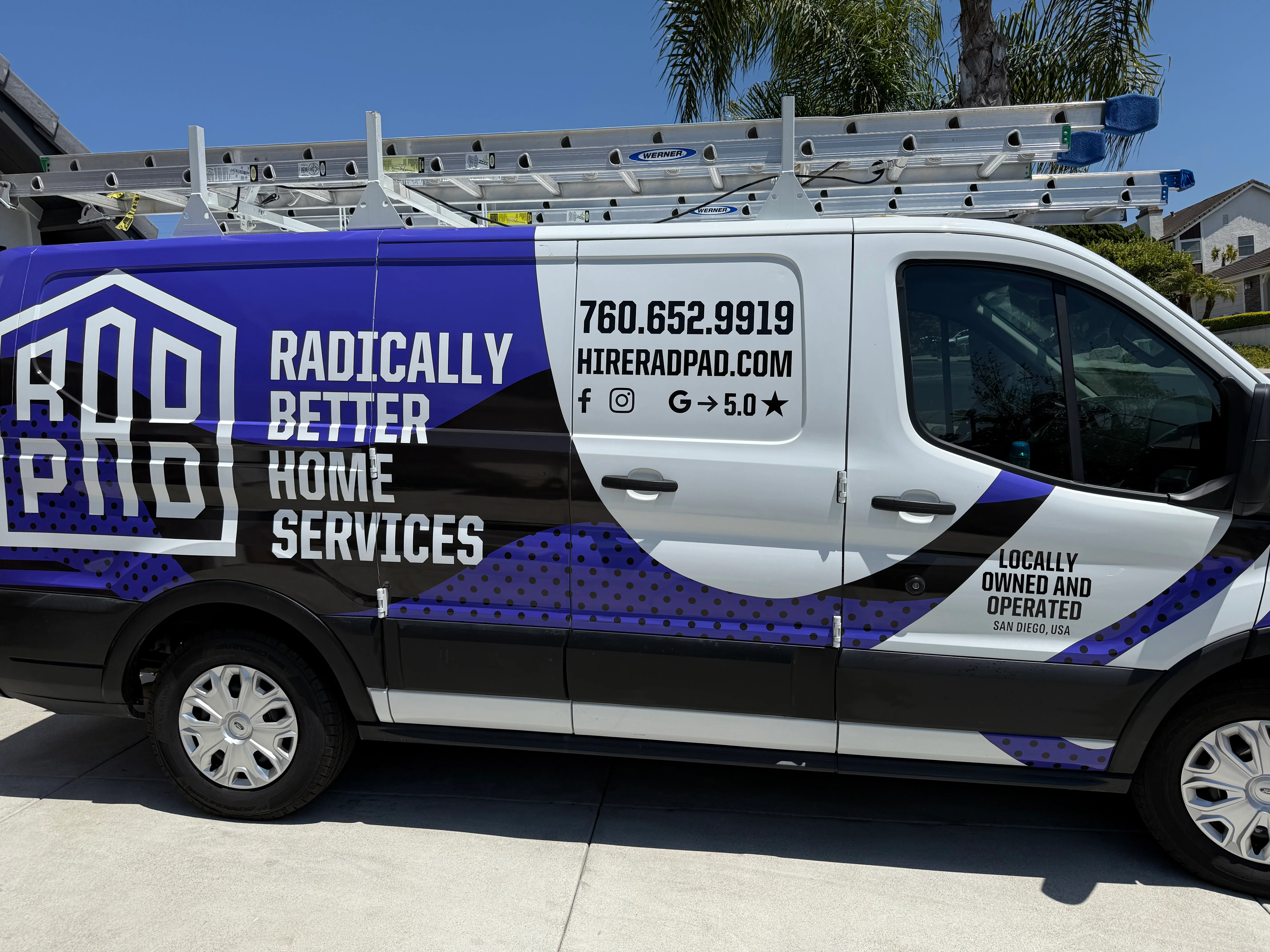 Blue and white service van with ladder rack and RadPad branding in San Diego
